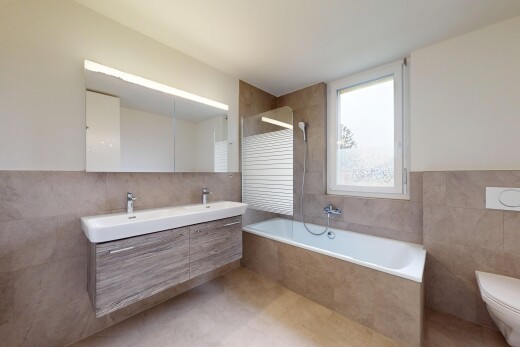 salle de bains avec lumière naturelle, mur en carrelage, douche, et miroir