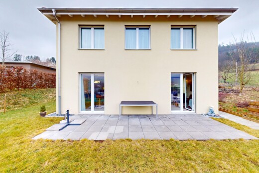 façade avec bardage en stuc, terrasse, et pelouse