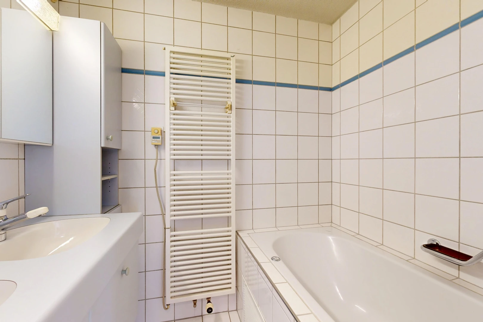 salle de bains avec radiateur, chauffe-serviettes, salle de bain complète, évier, et mur en carrelage