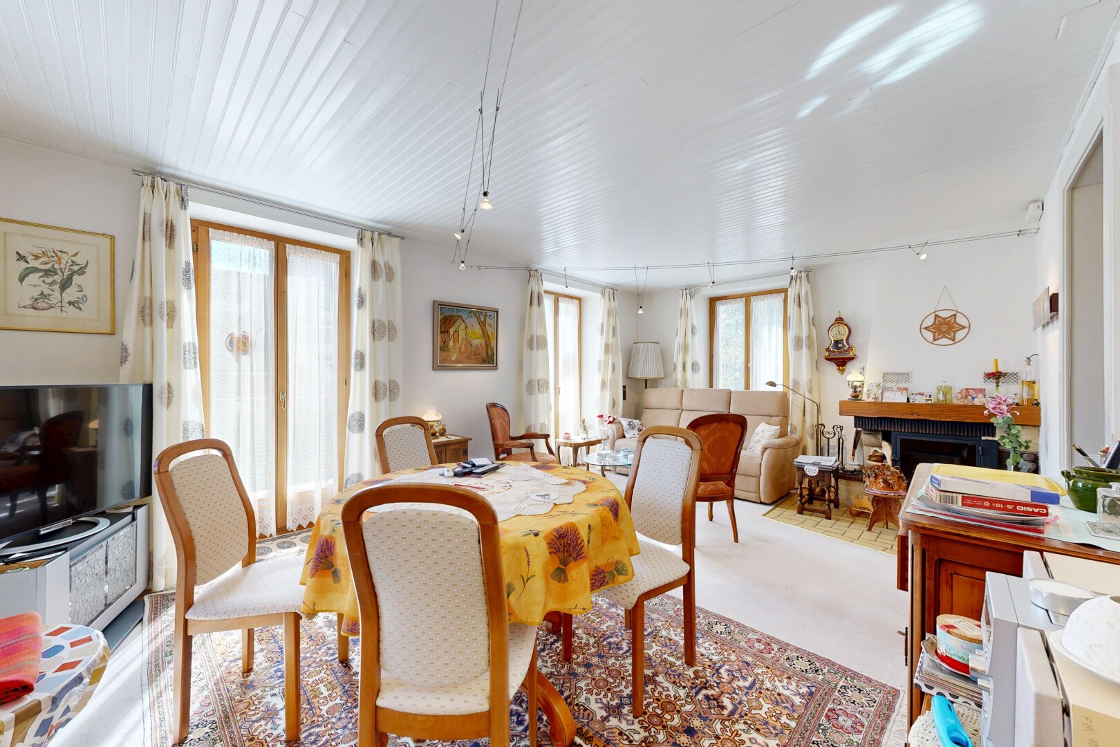 salle à manger avec télévision, natural light, lumière naturelle, drywall, et cloison sèche