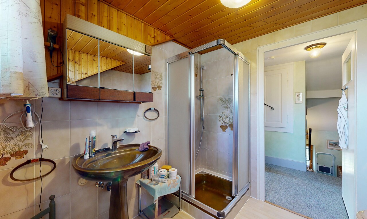 salle de bains avec miroir, douche, tile shower, salle de bain complète, et inside property