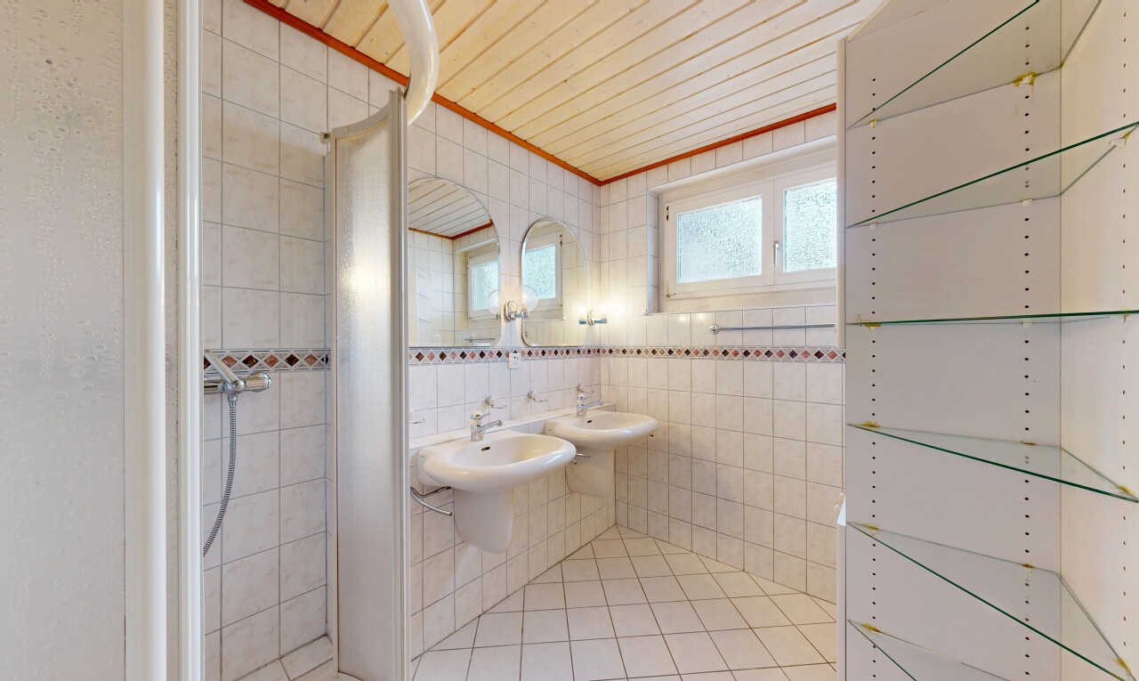 bad mit spiegel, dusche, fliesenwand, und natürliches licht