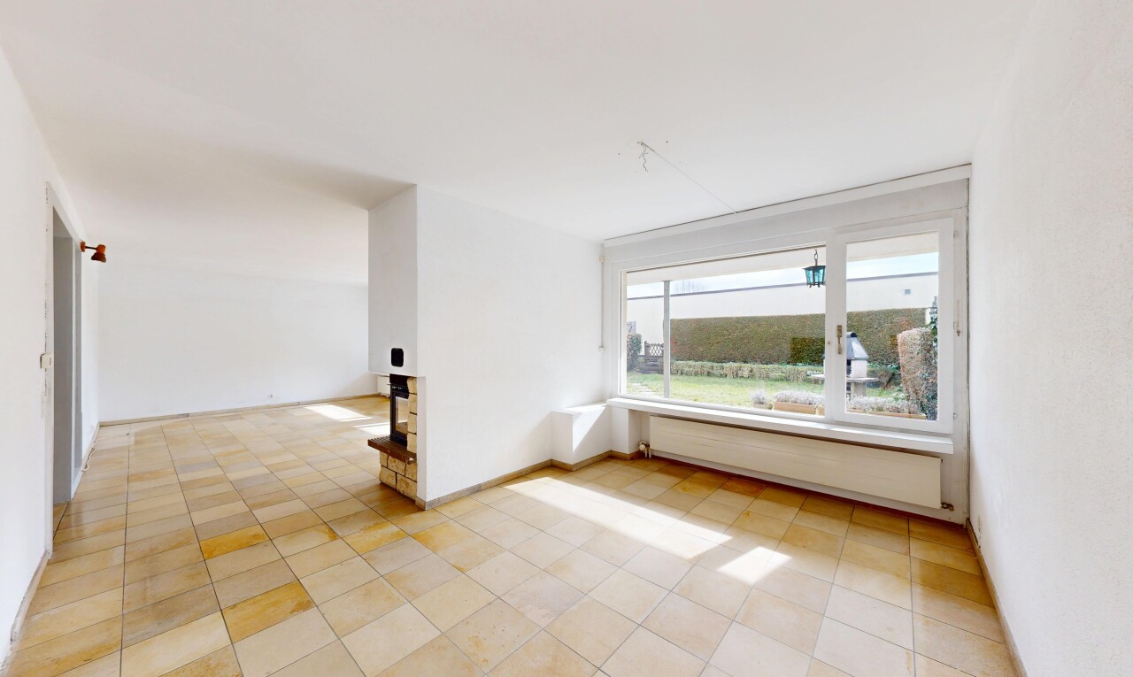 leerer raum mit fußleistenheizung, natürliches licht, gipskartonwand, und fliesenboden
