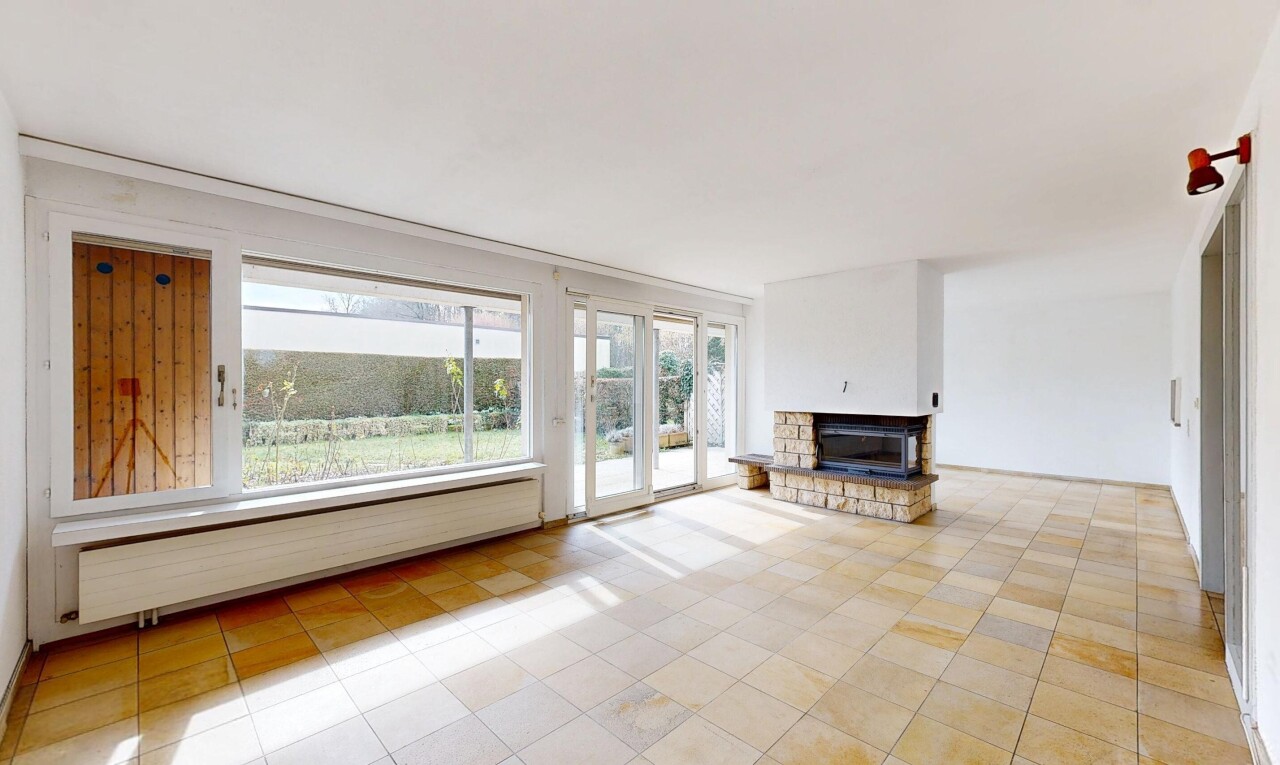 leerer raum mit fußleistenheizung, natürliches licht, gipskartonwand, und kamin