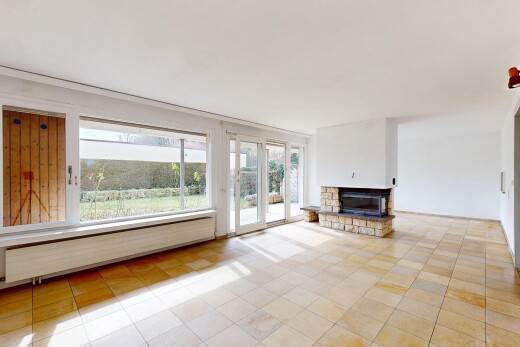 leerer raum mit fußleistenheizung, natürliches licht, gipskartonwand, und kamin