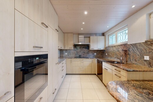 küche mit dunstabzugshaube, stein arbeitsplatten, küchenrückwand beim herd, geschirrspülmaschine, und waschbecken