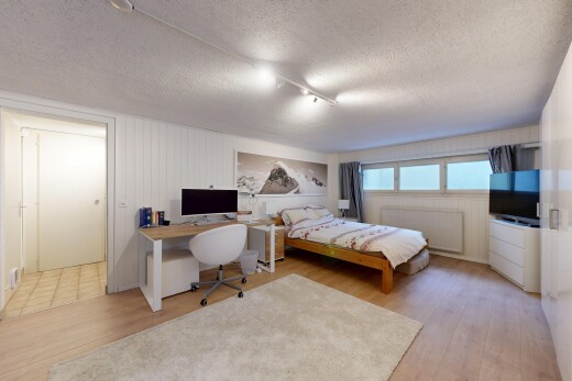 chambre avec plafond texturé, textured ceiling, radiateur, espace bureau, et télévision