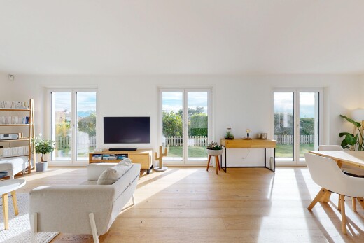 salon / salle à manger avec télévision, lumière naturelle, natural light, sol en finition bois, et wood finish floor