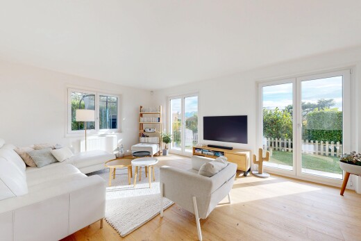 salon avec télévision, wood finish floor, sol en finition bois, natural light, et lumière naturelle