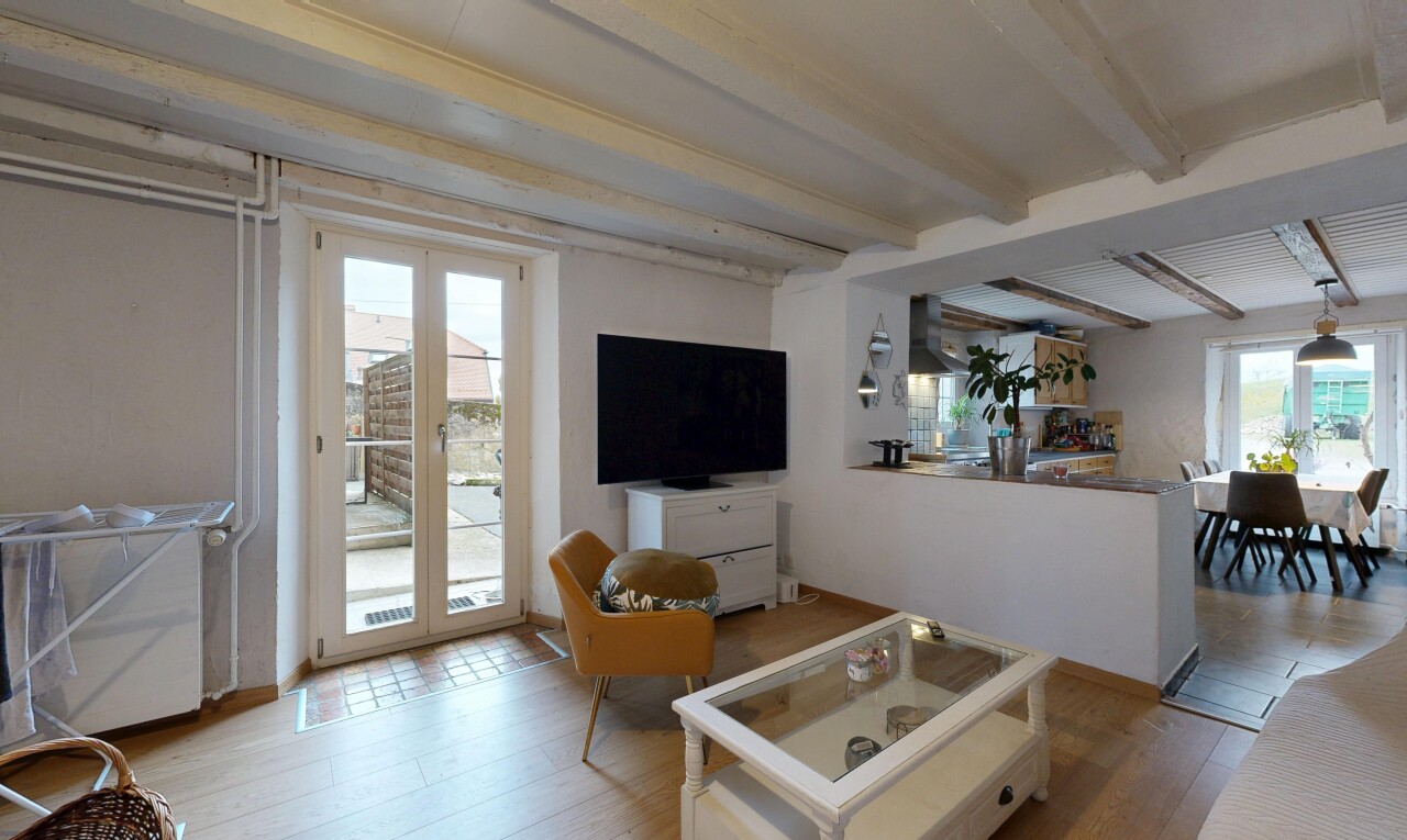 salon / salle à manger avec plafond à poutres, beamed ceiling, télévision, inside property, et lumière naturelle