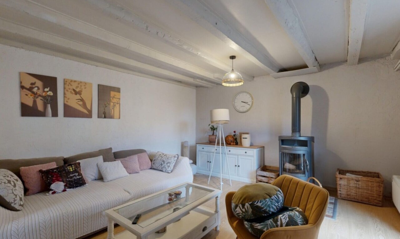salon avec poêle à bois, plafond à poutres, beamed ceiling, inside property, et cloison sèche