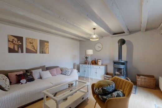 salon avec poêle à bois, plafond à poutres, beamed ceiling, inside property, et cloison sèche