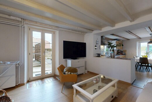 salon / salle à manger avec plafond à poutres, beamed ceiling, télévision, inside property, et lumière naturelle