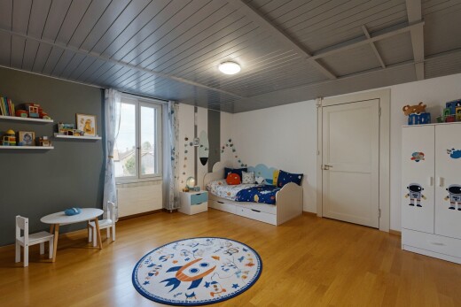 chambre avec sol en finition bois, wood finish floor, télévision, lumière naturelle, et natural light