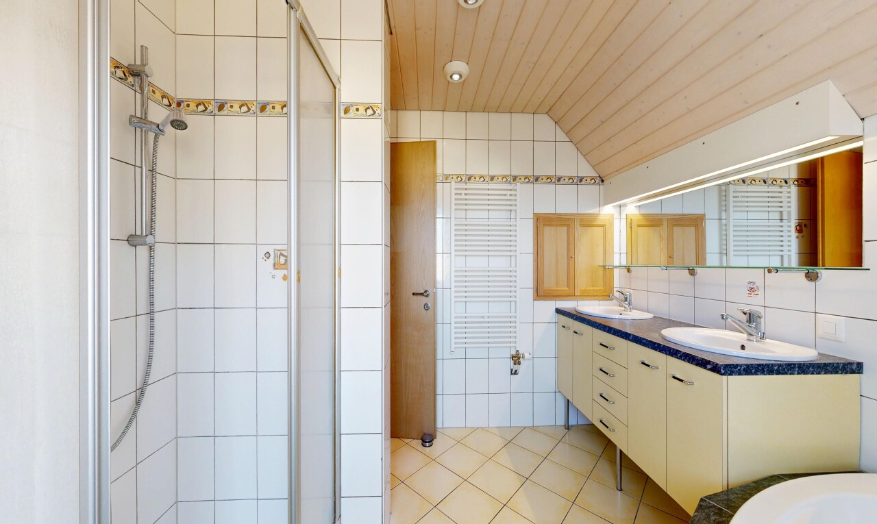 salle de bains avec douche, light floor, salle de bain complète, double vasque, et mur en carrelage