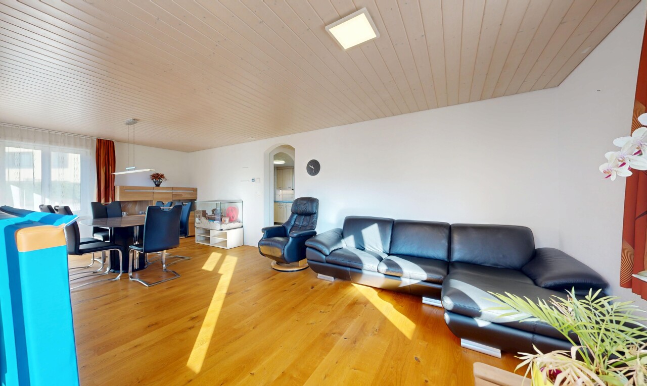 salon / salle à manger avec passages en arc, wood finish floor, sol en finition bois, drywall, et cloison sèche