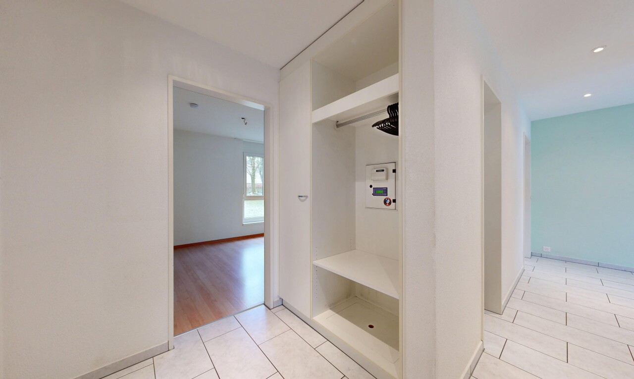 hallway featuring baseboards and light tile patterned flooring