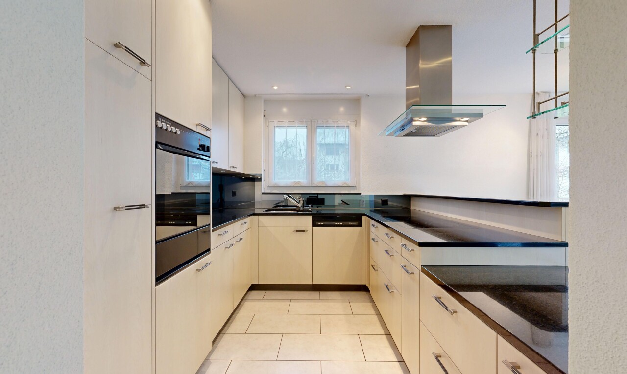 kitchen featuring range hood, oven, dishwasher, light tile patterned floors, and dark stone counters
