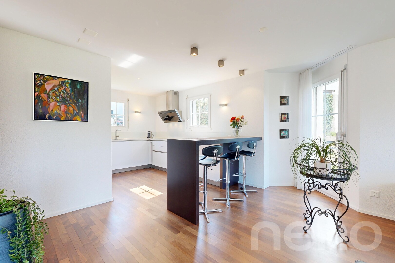 kitchen with white cabinetry, a breakfast bar, light wood-style flooring, light countertops, and modern cabinets