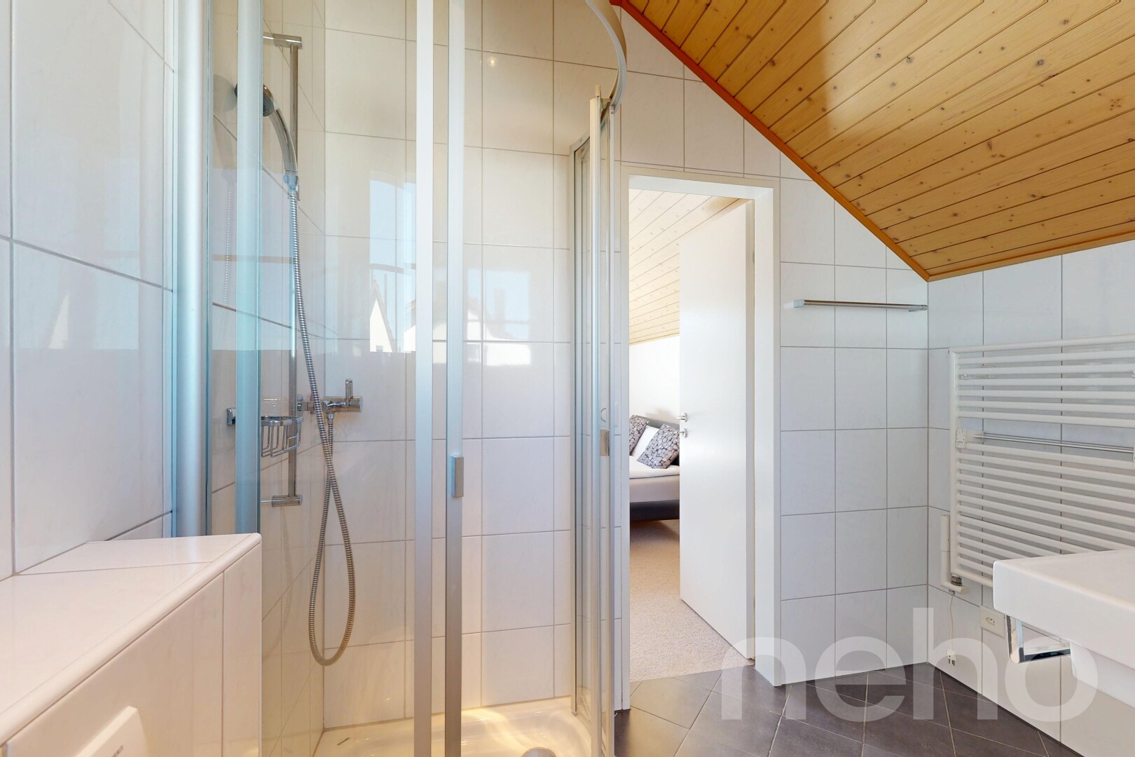 full bathroom with radiator heating unit, tile walls, a shower stall, dark tile patterned flooring, and ensuite bath