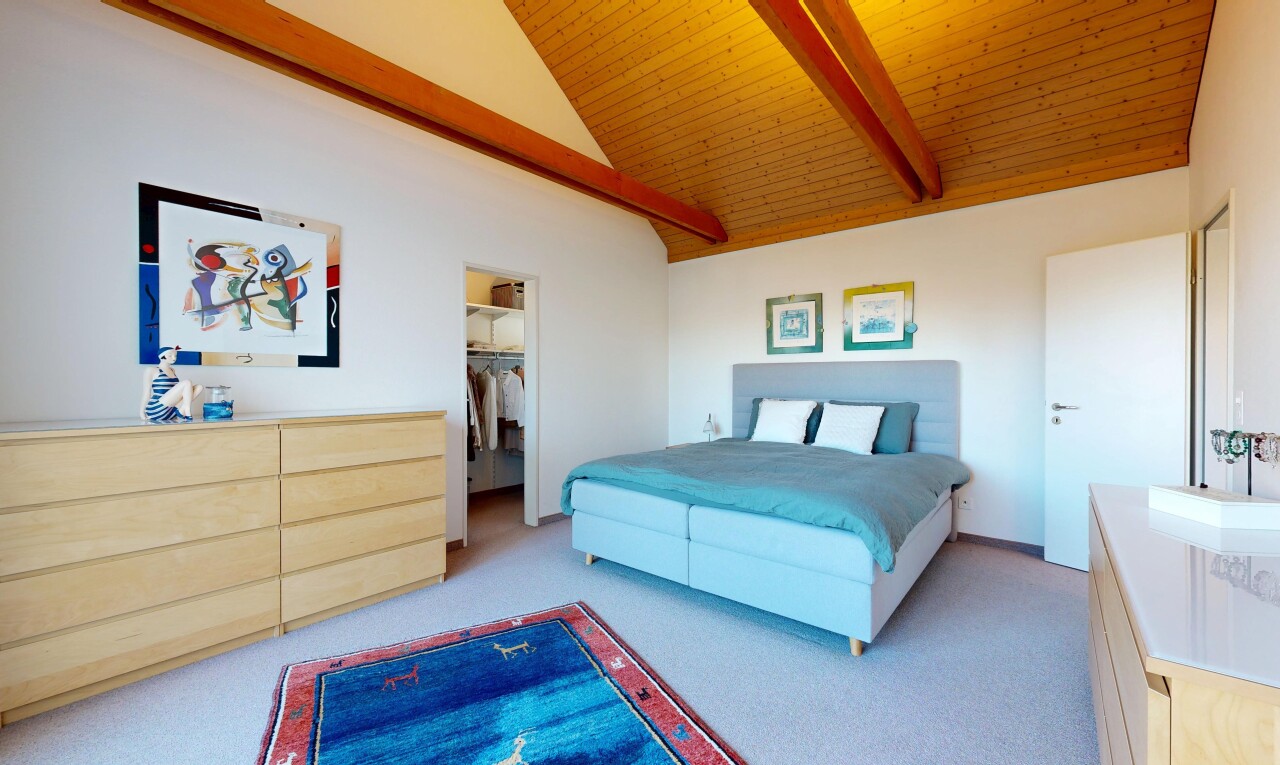 room with light colored carpet, vaulted ceiling with beams, a spacious closet, and wooden ceiling