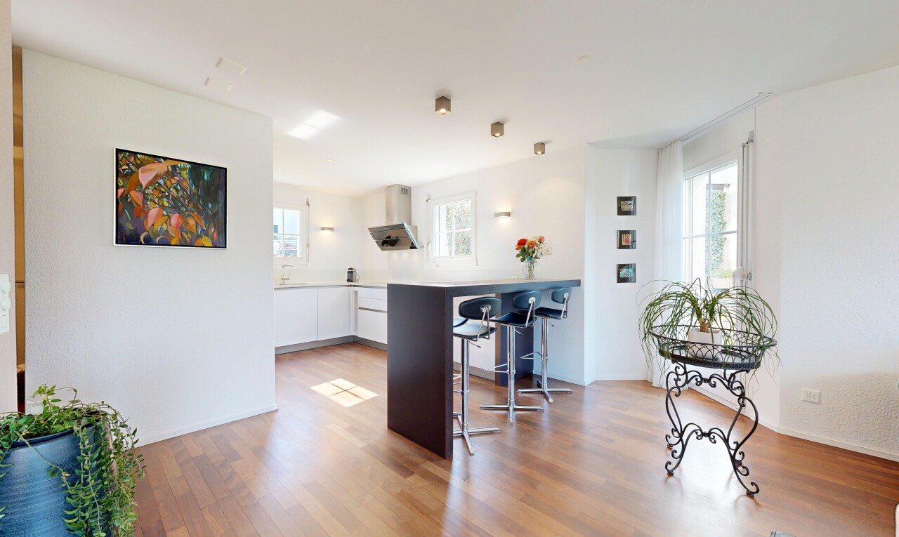 kitchen with white cabinetry, a breakfast bar, light wood-style flooring, light countertops, and modern cabinets