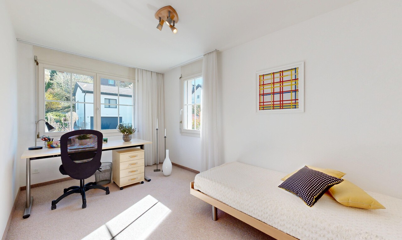 room featuring light colored carpet and a desk