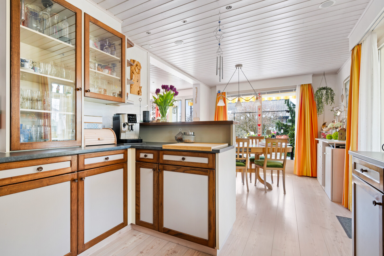 kitchen featuring decorative light fixtures, glass fronted cabinets, wood finish cabinetry, light wood-style flooring, and wooden ceiling