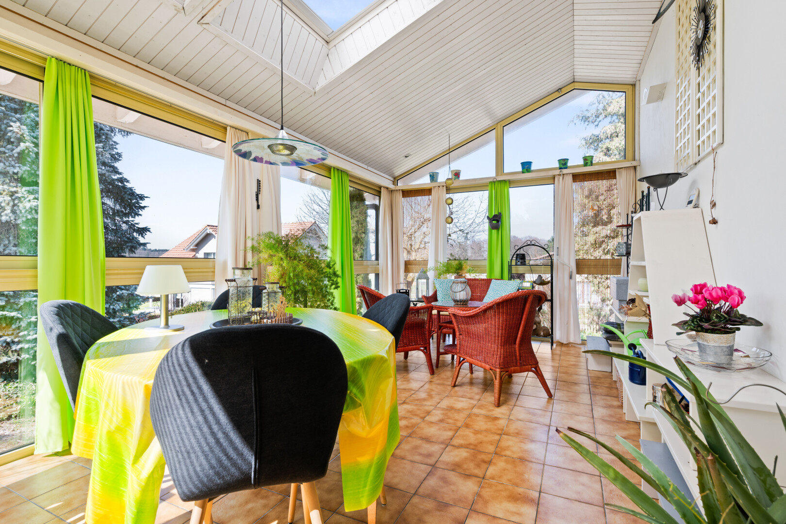 dining room featuring vaulted ceiling, a skylight, and light tile patterned flooring