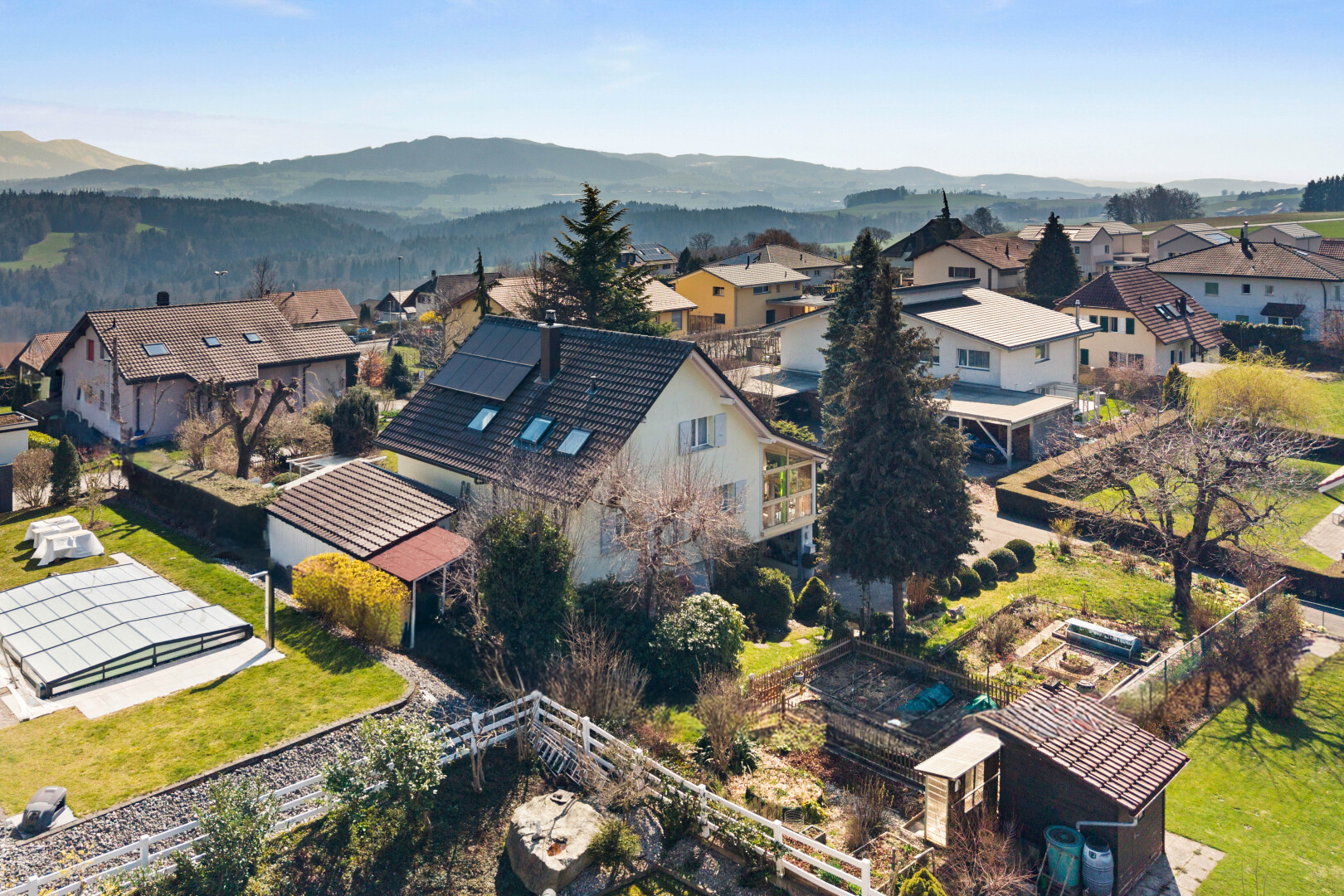 outdoor house with solar panels, a residential view, a balcony, and a mountain view