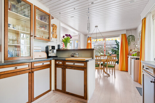 kitchen featuring decorative light fixtures, glass fronted cabinets, wood finish cabinetry, light wood-style flooring, and wooden ceiling