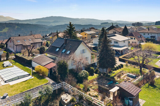 outdoor house with solar panels, a residential view, a balcony, and a mountain view