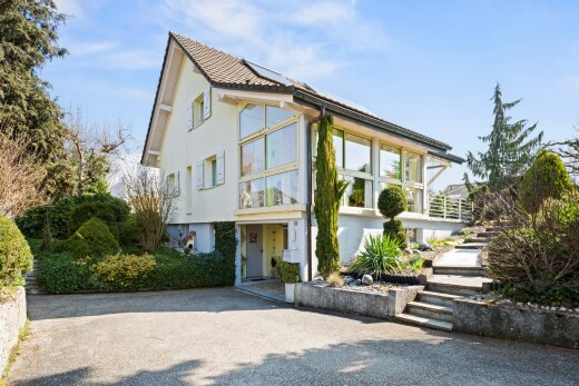 view of home with stucco siding and roof mounted solar panels