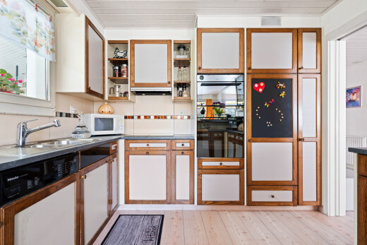 dual tone kitchen with dishwasher, light wood finished floors, two tone cabinets, white microwave, and open shelves