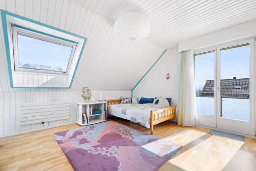 room / bedroom featuring lofted ceiling, light wood finished floors, access to outside, wood walls, and a skylight