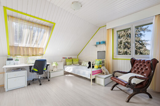 room with light wood-style flooring, a desk, and vaulted ceiling