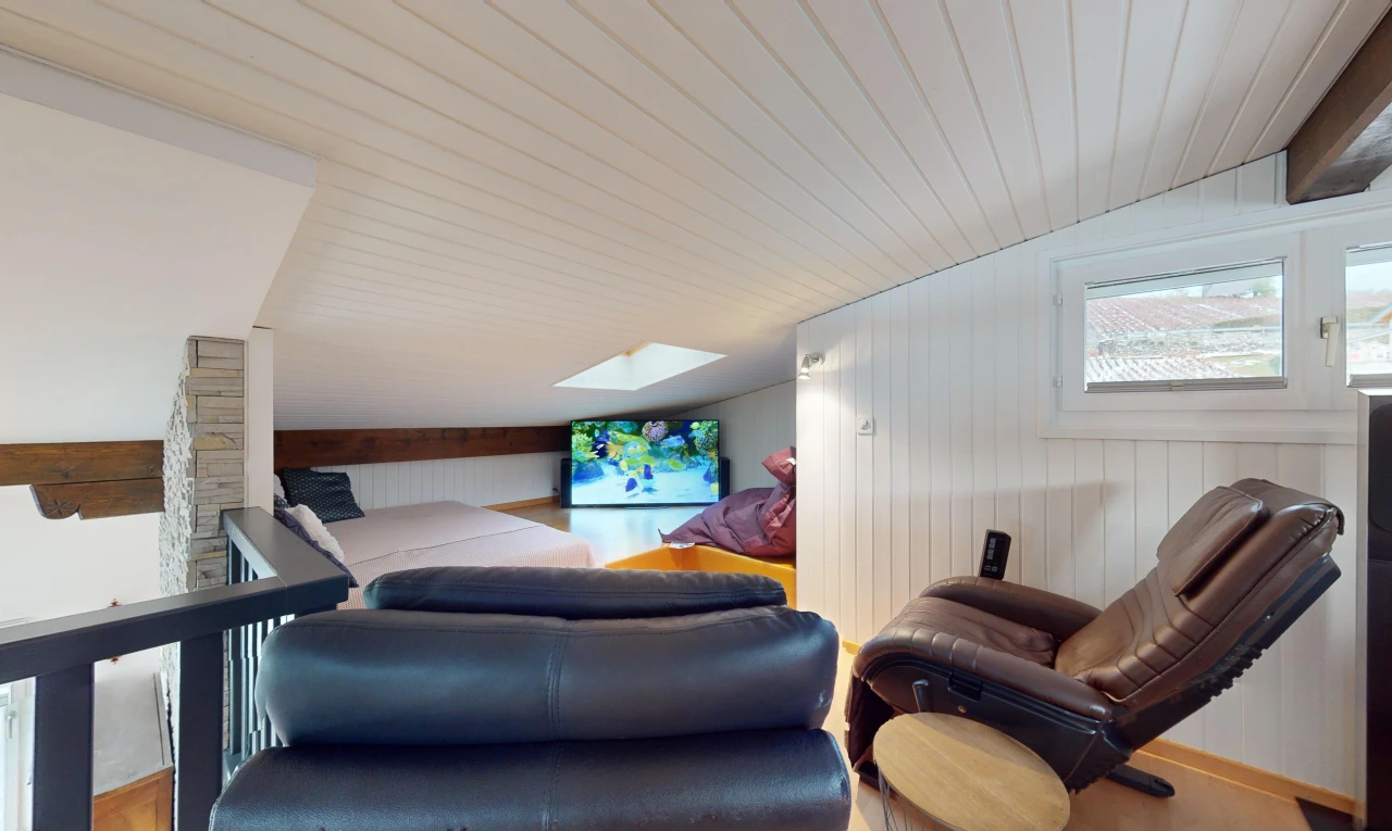 wohnzimmer mit dachfenster, fernseher, dachschräge, holzwand, und natürliches licht