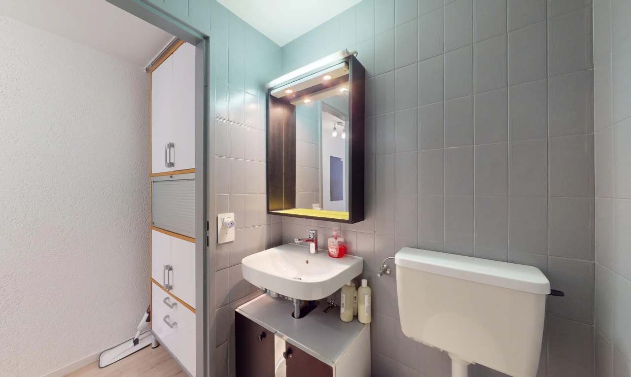 bad mit fliesenwand, spiegel, toilette, parkettboden, und waschbecken