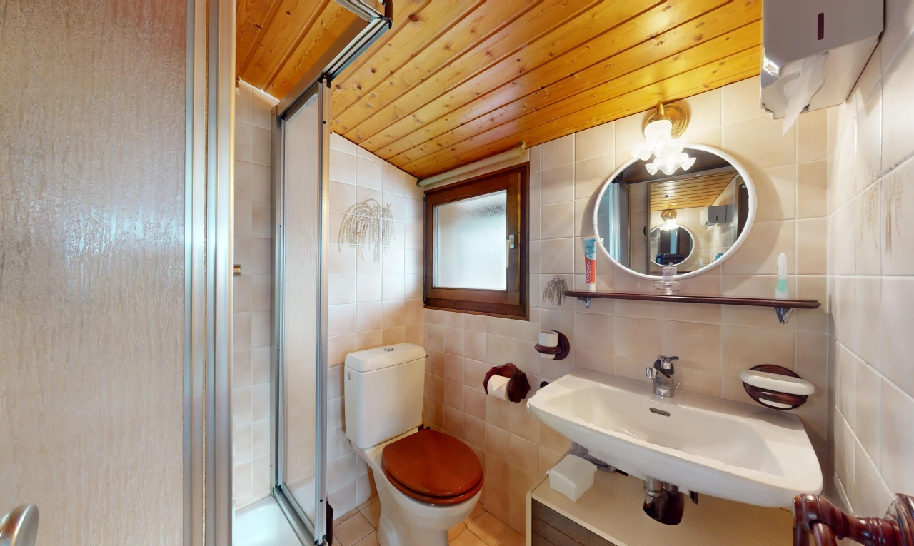 bad mit fliesenwand, spiegel, und holzdecke