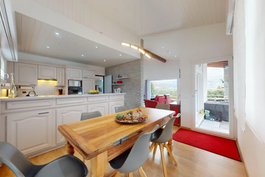 salle à manger avec lumière naturelle, poutres apparentes, et plancher de bois
