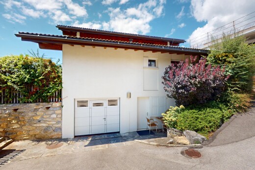 außenansicht mit eingebaute garage, property visible, day time, stuckverkleidung, und auffahrt