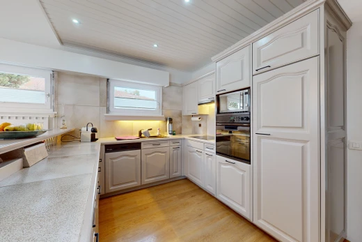 cuisine avec meubles avec moulures, plan de travail, meubles à panneaux en relief, lumière naturelle, et four