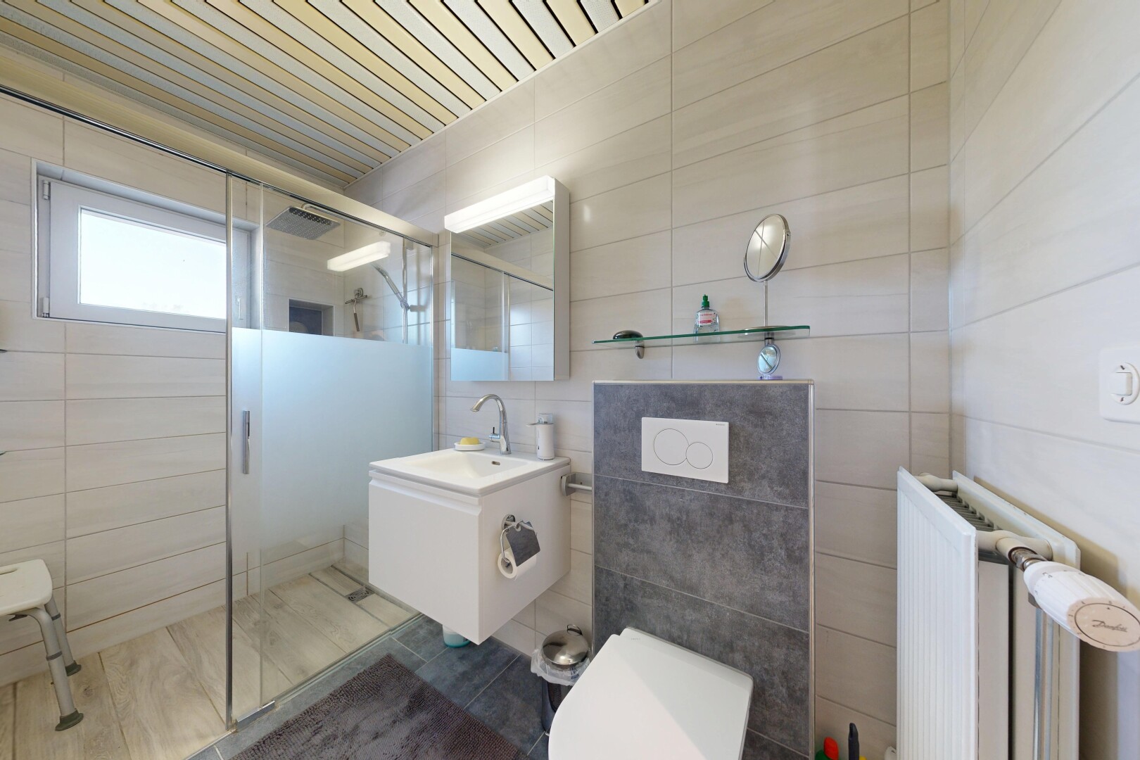 salle de bains avec douche, salle de bain complète, miroir, radiateur, et lavabo (ou coiffeuse selon le contexte)