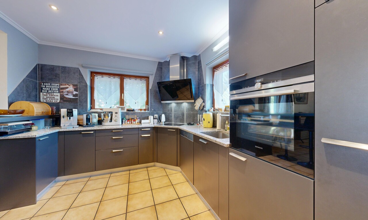 cuisine avec light countertops, hotte, four, light floor, et éclairage encastré