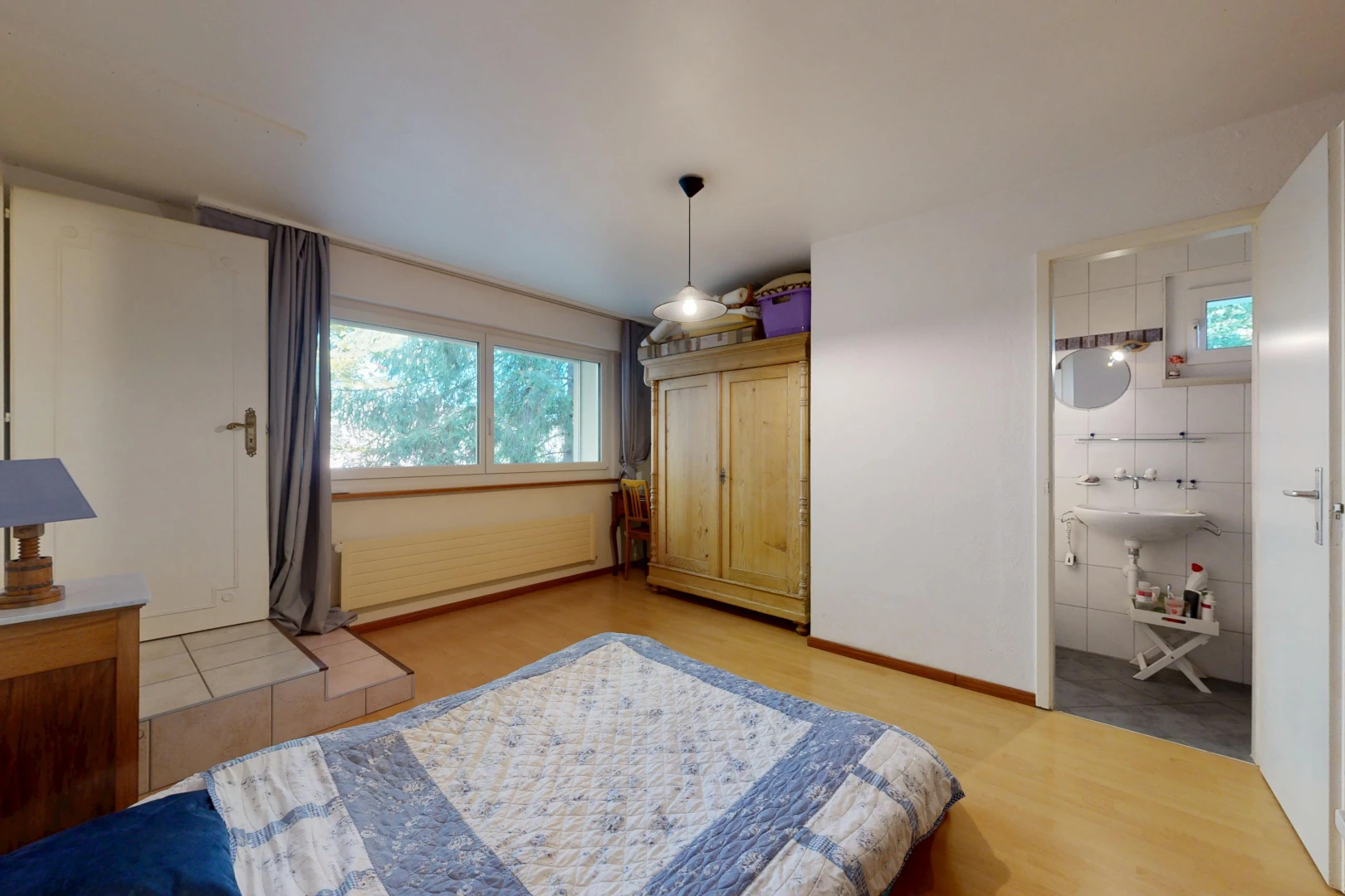 zimmer / schlafzimmer mit pendelleuchte, waschbecken, gipskartonwand, drywall, und holzfußboden