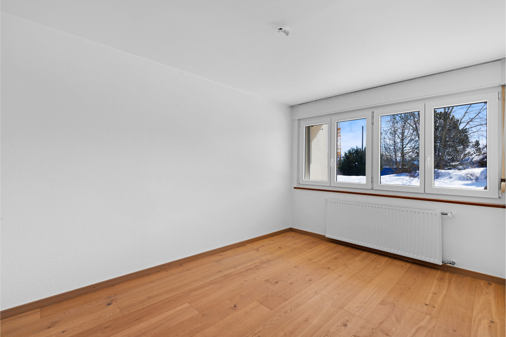pièce vide avec radiateur, sol en finition bois, wood finish floor, inside property, et cloison sèche