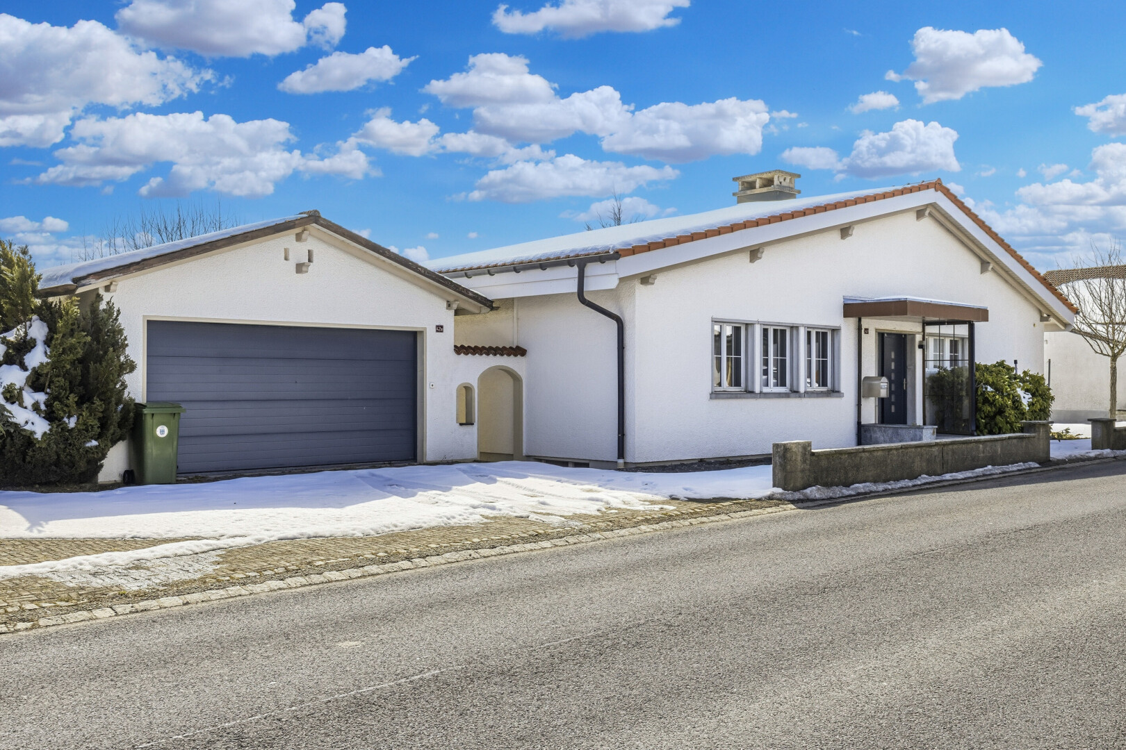 façade avec day time, property visible, bardage en stuc, et garage attaché