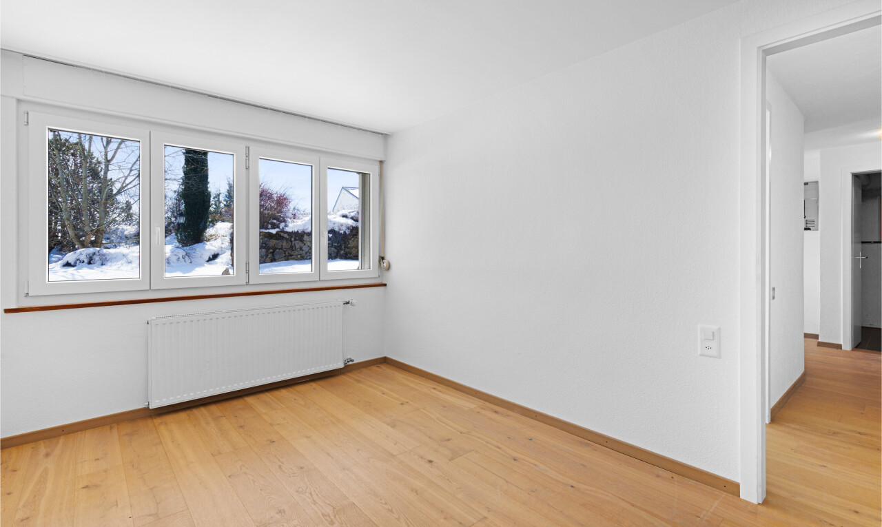 pièce vide avec radiateur, wood finish floor, sol en finition bois, drywall, et cloison sèche