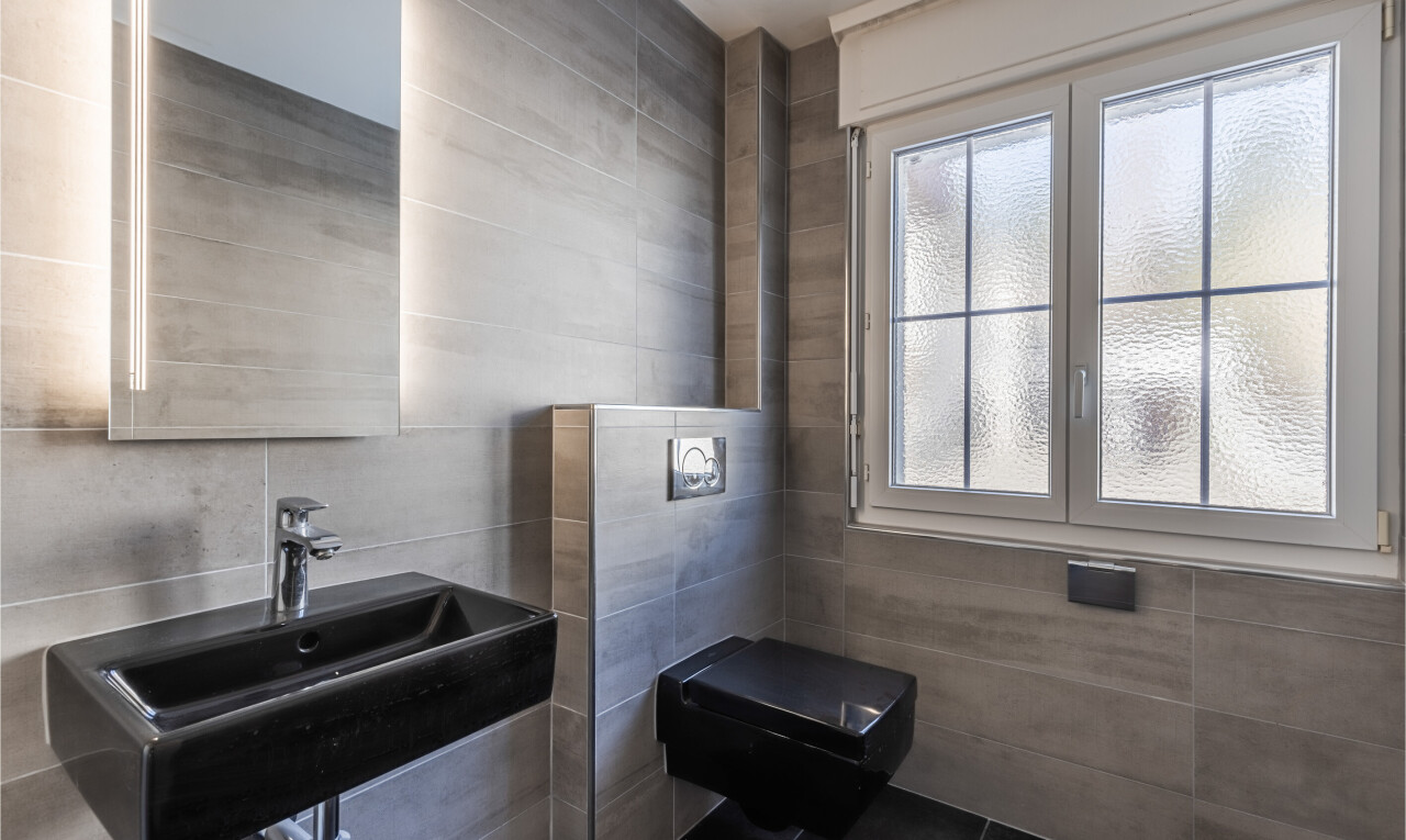 salle de bains avec tile wall, mur en carrelage, inside property, natural light, et lumière naturelle
