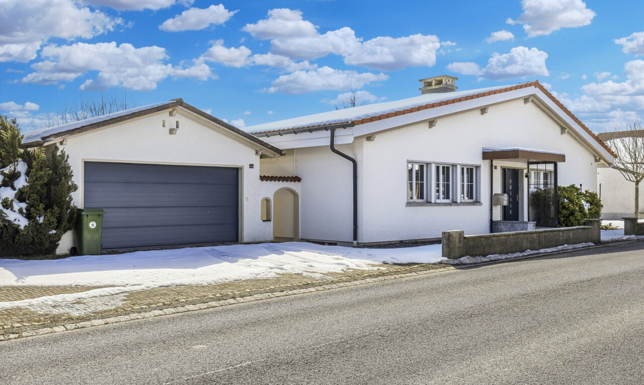 façade avec day time, property visible, bardage en stuc, et garage attaché
